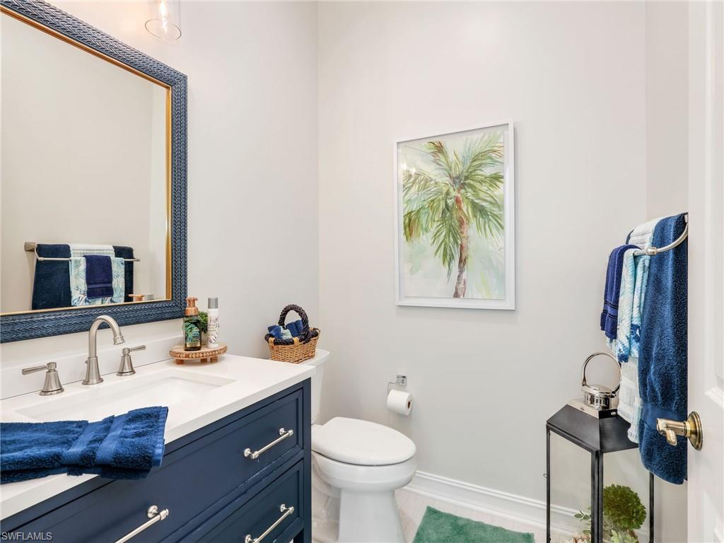 6096 Dogleg Drive Naples, FL 34113 - Photo 34 of 49 a bathroom with a sink a toilet and a mirror