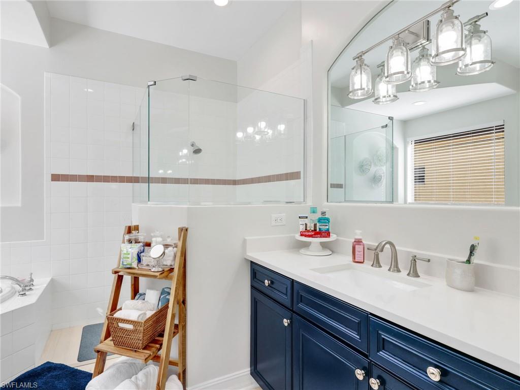 6096 Dogleg Drive Naples, FL 34113 - Photo 36 of 49 a bathroom with a sink vanity and a mirror