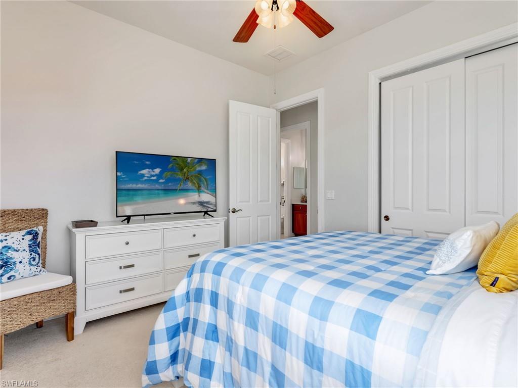 6096 Dogleg Drive Naples, FL 34113 - Photo 39 of 49 a bedroom with a bed and a flat tv screen on dresser