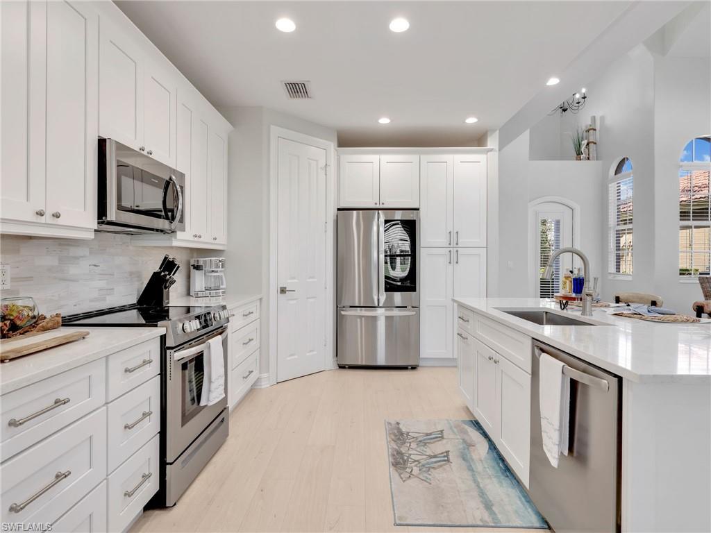 6096 Dogleg Drive Naples, FL 34113 - Photo 4 of 49 a kitchen with stainless steel appliances granite countertop a sink stove and refrigerator
