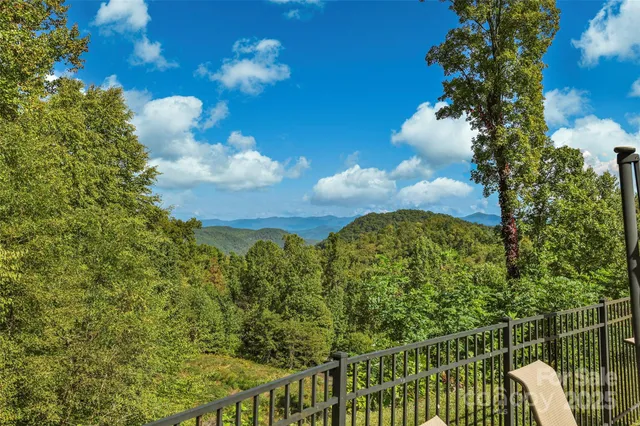 a living room with furniture a fireplace and floor to ceiling windows