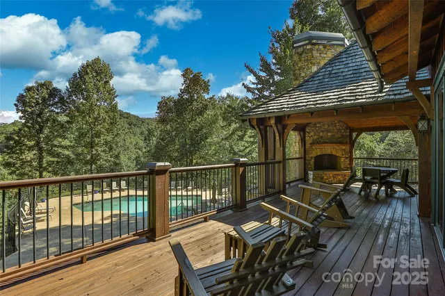 a balcony with wooden floor outdoor seating and yard in the back