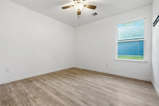 wooden floor in an empty room with a window