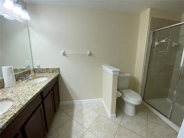 a bathroom with a granite countertop sink a toilet and a mirror