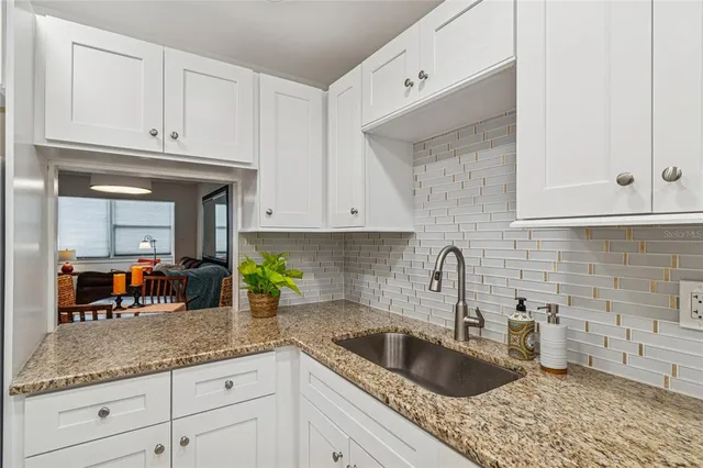 a kitchen with granite countertop a sink stainless steel appliances and cabinets