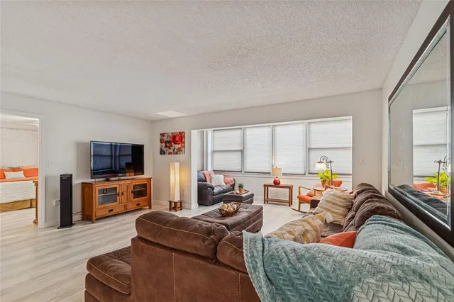 a living room with furniture a flat screen tv and a large window