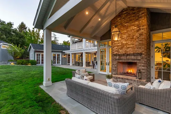a view of a patio with couches plants and large tree