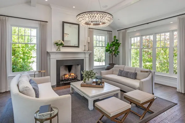 a living room with furniture a chandelier and a fireplace