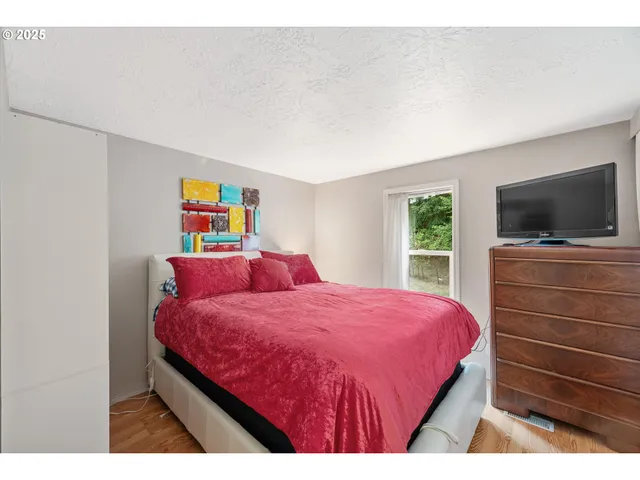 a bedroom with a bed and painting on the wall