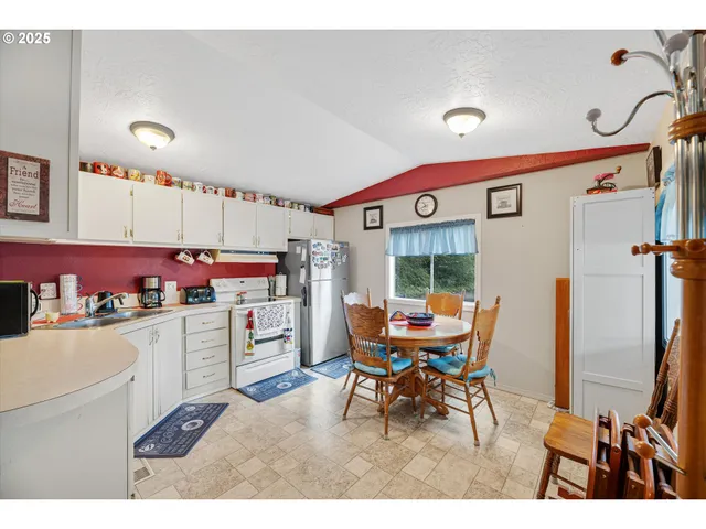 a kitchen with a refrigerator and a stove top oven