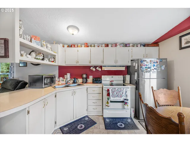 a kitchen with kitchen island a sink stove and white cabinets