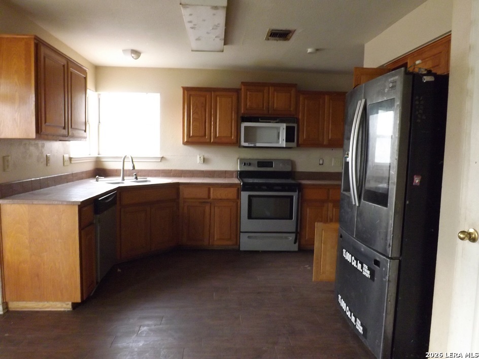 7110 Misty Ridge Drive Converse, TX 78109 - Photo 2 of 7 a kitchen with stainless steel appliances granite countertop a sink stove refrigerator and microwave