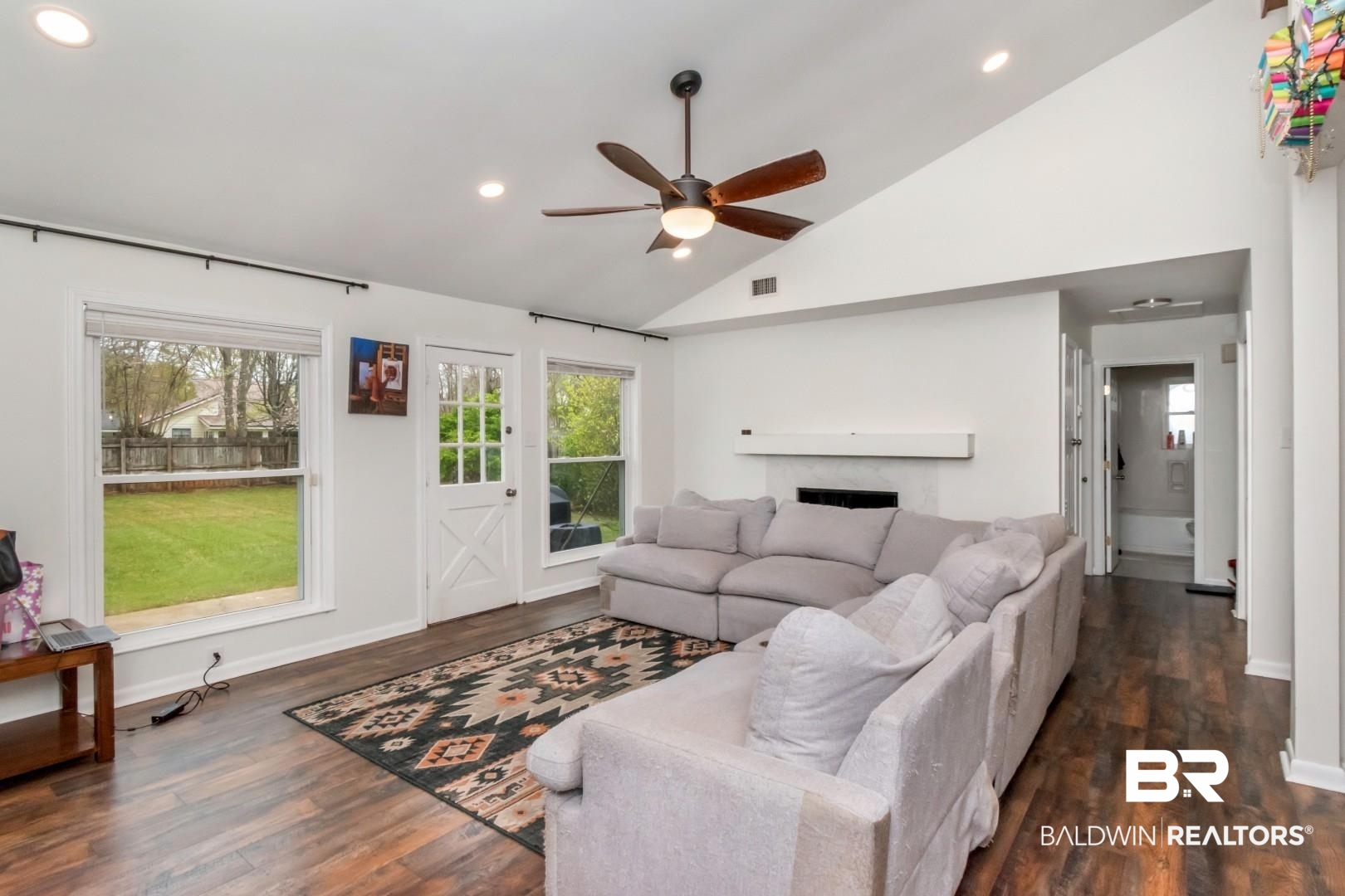 6208 Cottage Hill Road Mobile, AL 36609 - Photo 3 of 20 Living room with a ceiling fan, lofted ceiling, dark wood-style flooring, recessed lighting, and a fireplace