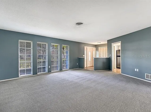 a view of an empty room with glass door and balcony