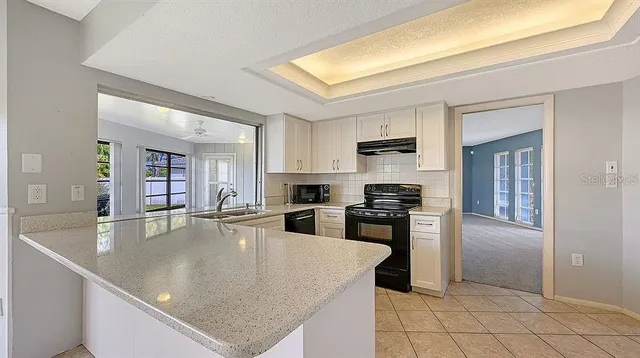 a large kitchen with stainless steel appliances granite countertop a large counter top and a stove top oven