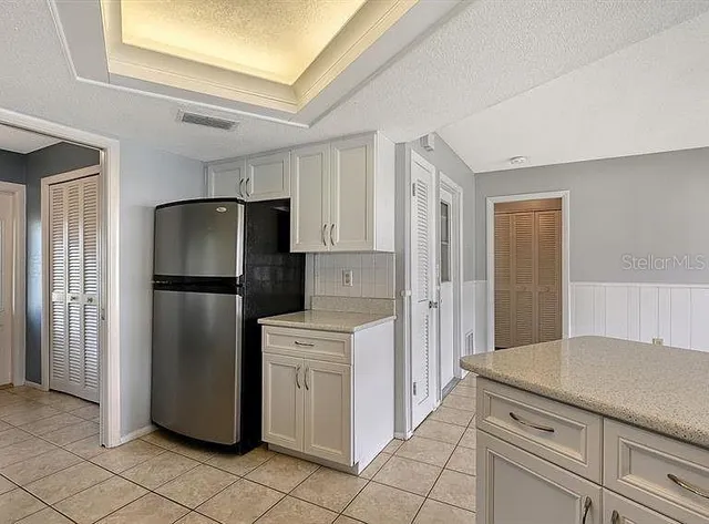 a kitchen with a refrigerator sink and cabinets