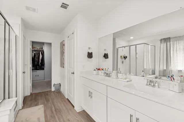 a bathroom with double vanity sinks a mirror and a shower