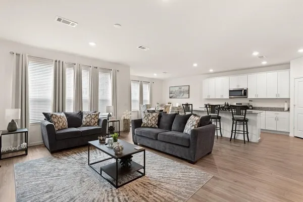 a living room with furniture and wooden floor