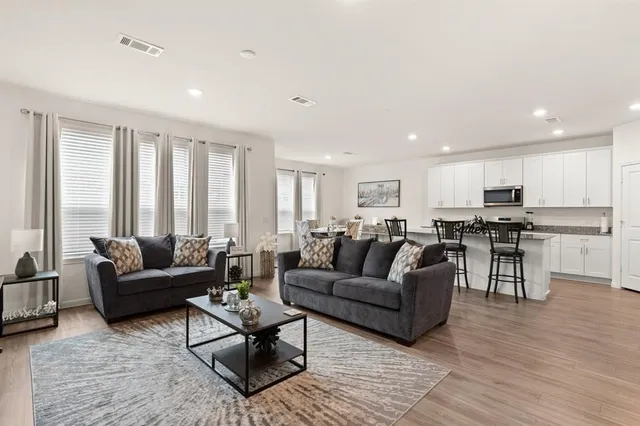 a living room with furniture and wooden floor
