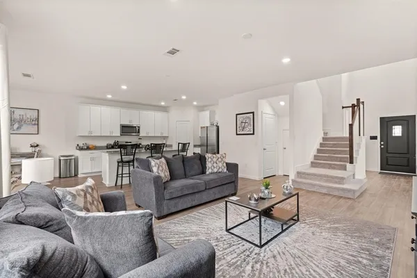 a living room with furniture and kitchen view