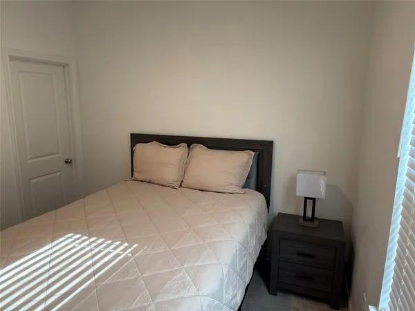 a bedroom with a bed and a night stand