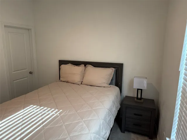 a bedroom with a bed and a night stand