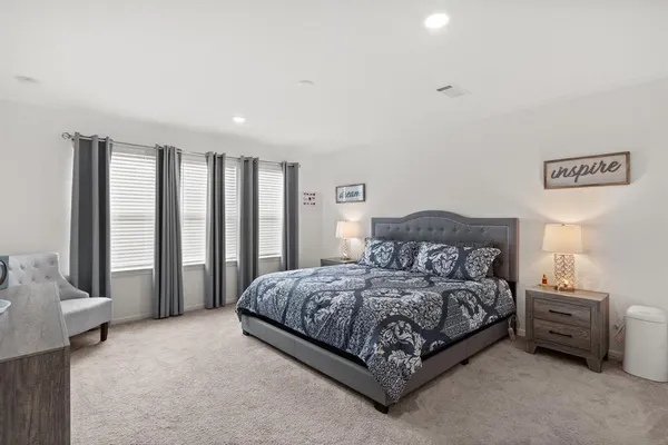 a spacious bedroom with a bed and a couch