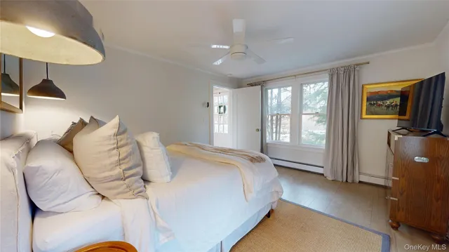 a spacious bedroom with a bed and a flat tv screen on the dresser