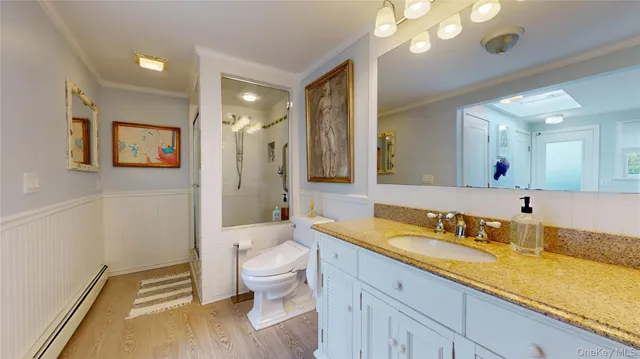 a spacious bathroom with a granite countertop sink a toilet and a large mirror