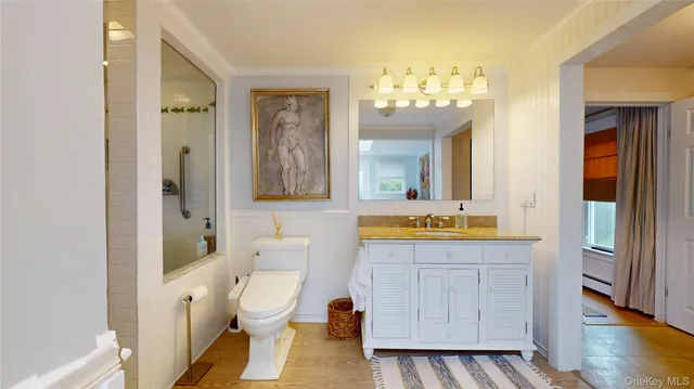 a spacious bathroom with a granite countertop toilet a sink and a mirror