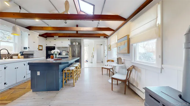 a kitchen with stainless steel appliances granite countertop a table chairs and a refrigerator
