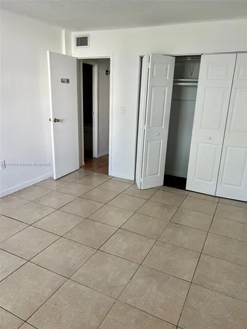 an empty room with wooden floor and cabinet door