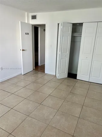 an empty room with wooden floor and cabinet door