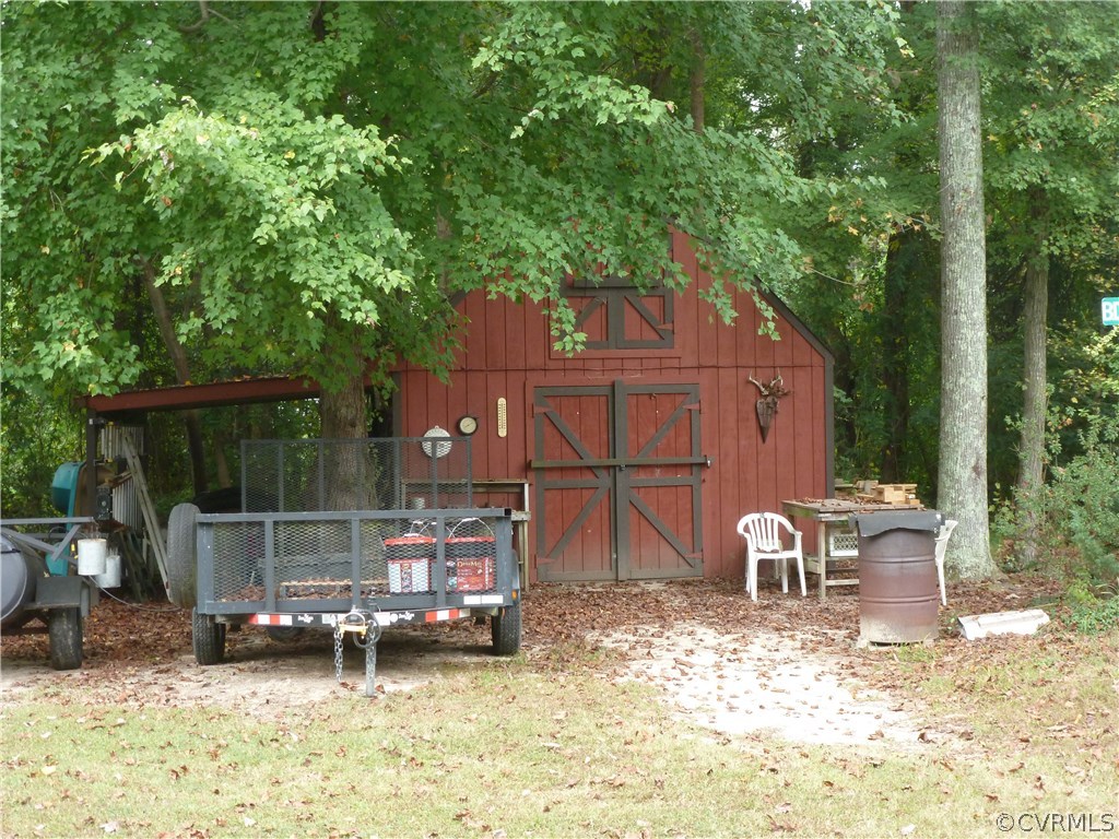 8725 Sandy Ridge Road Hopewell, VA 23860 - Photo 18 of 19 a backyard of a house with barbeque oven table and chairs