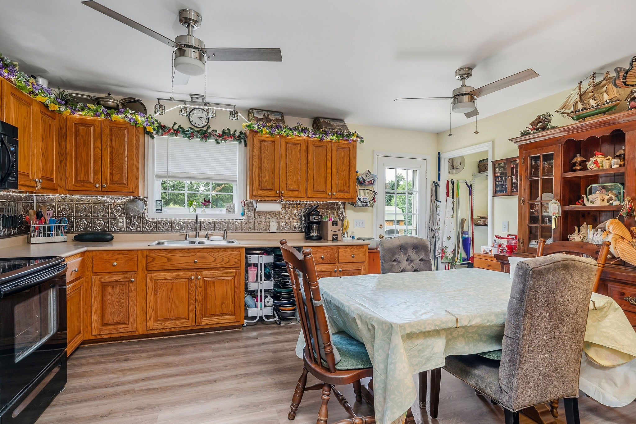 1565 Canada Flatt Road Cookeville, TN 38506 - Photo 6 of 28 a kitchen with stainless steel appliances granite countertop a stove a sink dishwasher a dining table and chairs with wooden floor
