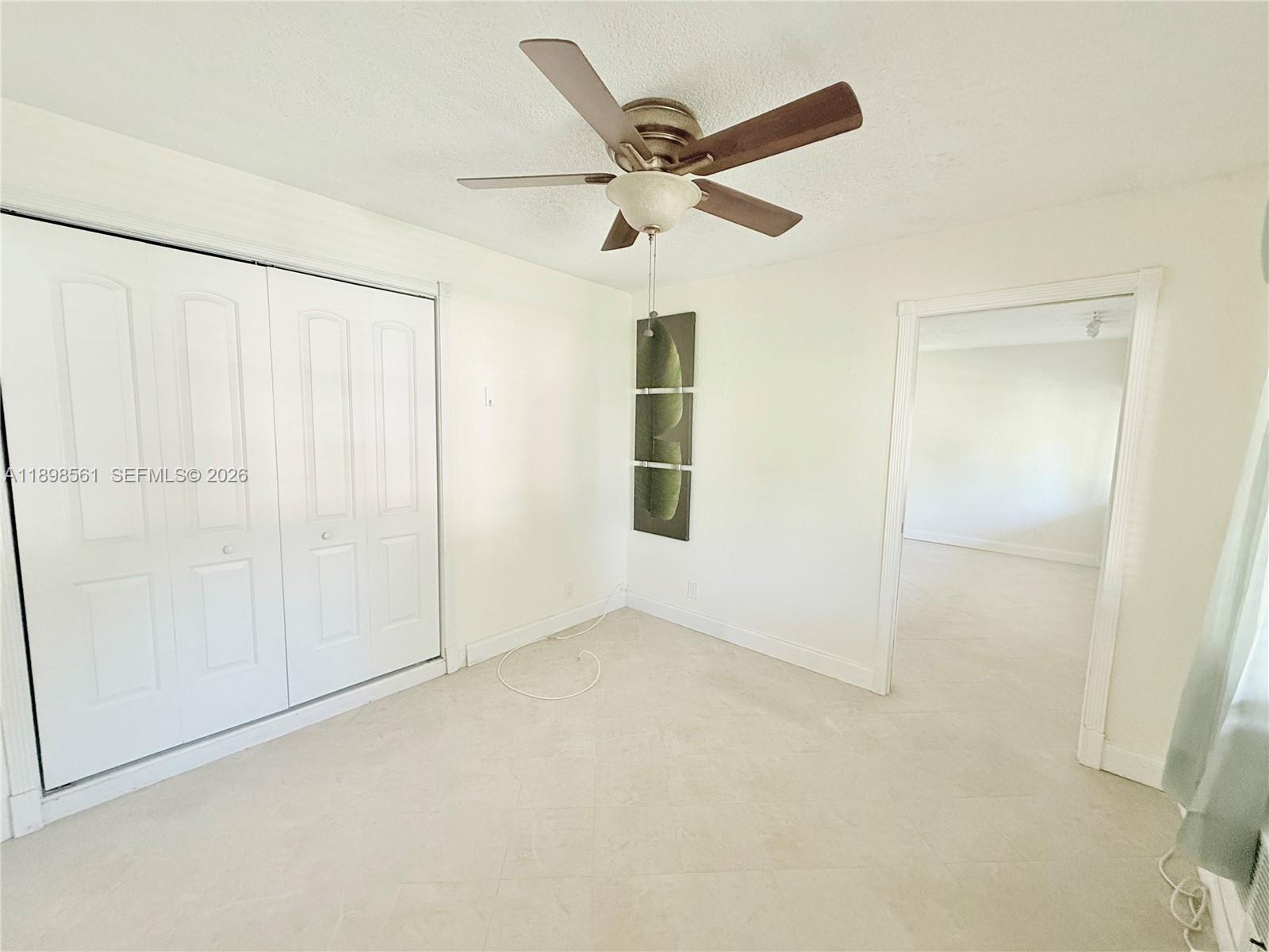 3600 Harrison Street, Unit 16B Hollywood, FL 33021 - Photo 16 of 34 an empty room with ceiling fan and window