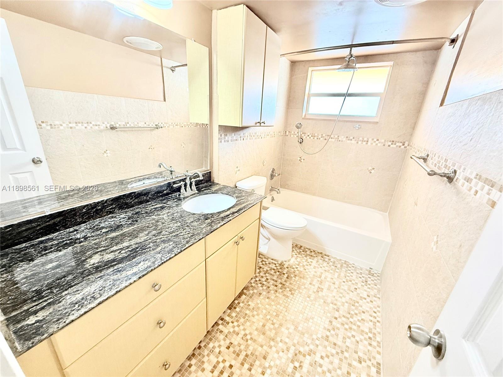 3600 Harrison Street, Unit 16B Hollywood, FL 33021 - Photo 3 of 34 a bathroom with a granite countertop sink a large mirror and a bathtub