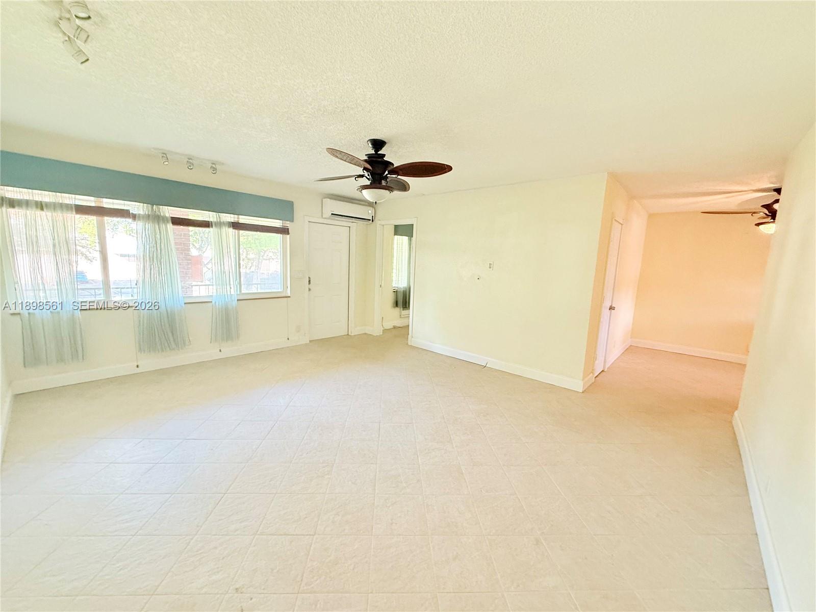 3600 Harrison Street, Unit 16B Hollywood, FL 33021 - Photo 9 of 34 an empty room with chandelier fan and windows
