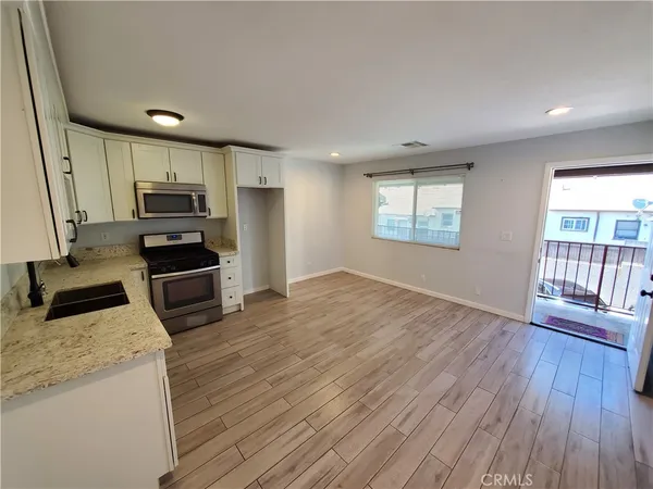 a kitchen with granite countertop a stove a sink and a refrigerator