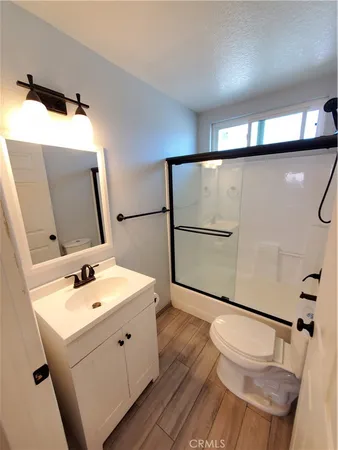 a bathroom with a sink mirror vanity and toilet