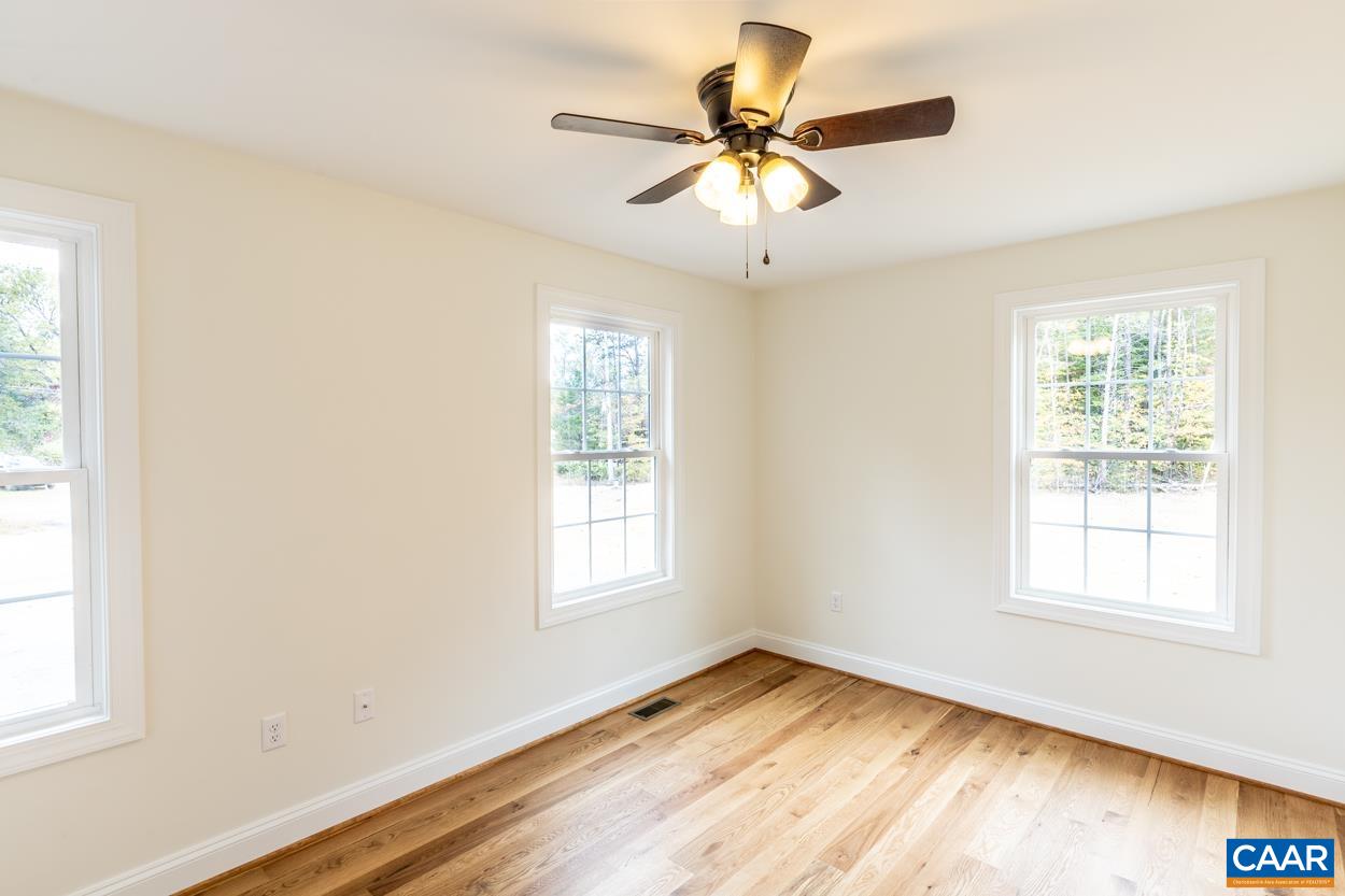 258 Twymans Mill Road Radiant, VA 22732 - Photo 36 of 59 an empty room with wooden floor fan and windows