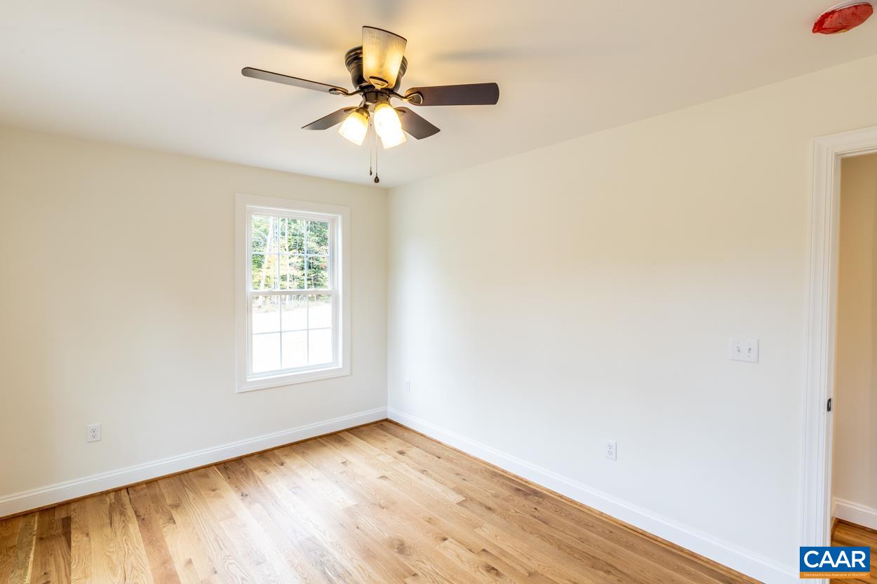 258 Twymans Mill Road Radiant, VA 22732 - Photo 38 of 59 an empty room with wooden floor fan and windows