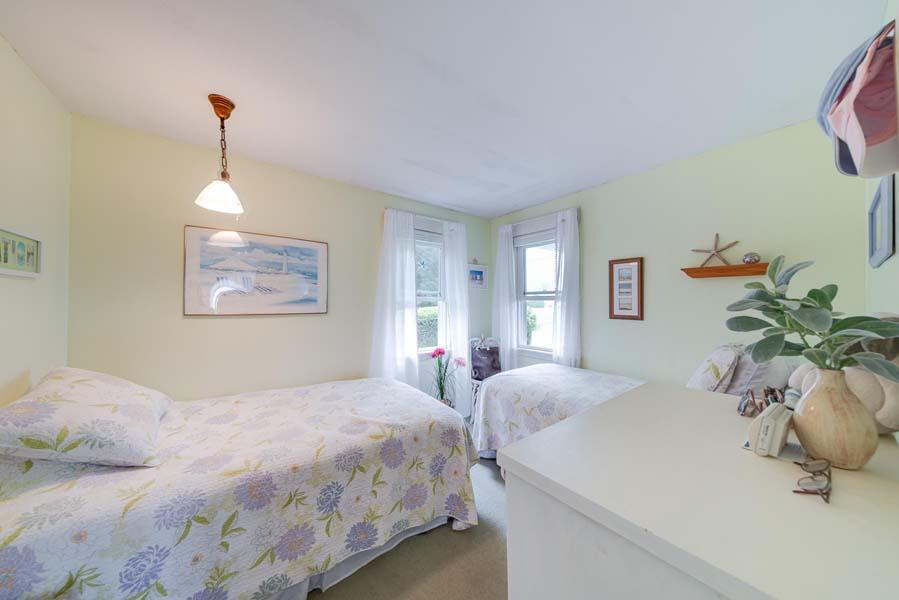 139 Shore Road Truro, MA 02666 - Photo 26 of 30 a bedroom with a large bed and a chandelier