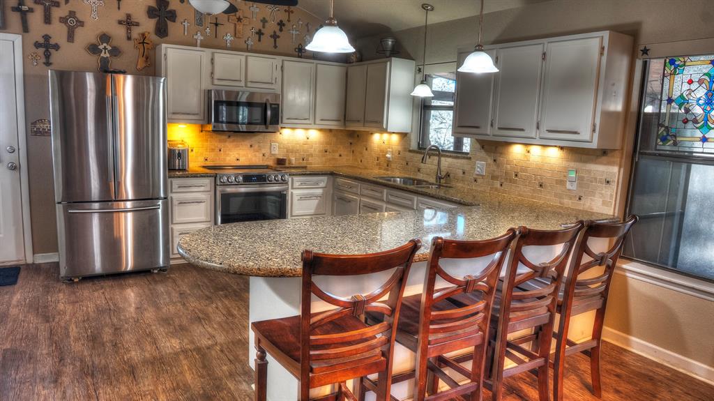 187 Roy Chisum Road Leakey, TX 78873 - Photo 22 of 40 a kitchen with a table chairs and refrigerator