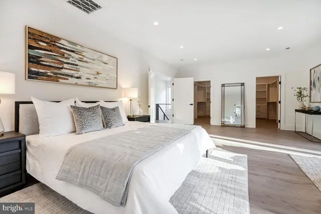 a spacious bedroom with a large bed and a chandelier