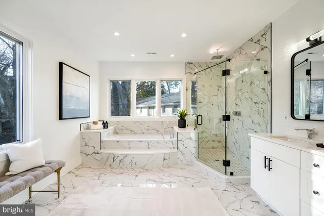 a spacious bathroom with a tub sink and mirror