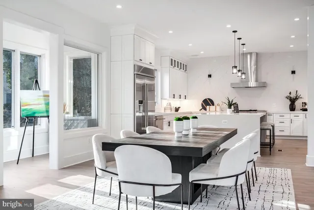a dining room with furniture a large window and kitchen view