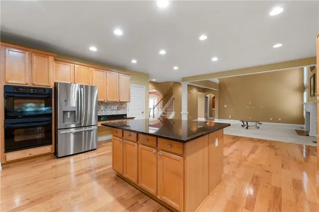 a kitchen with stainless steel appliances granite countertop a refrigerator and a sink
