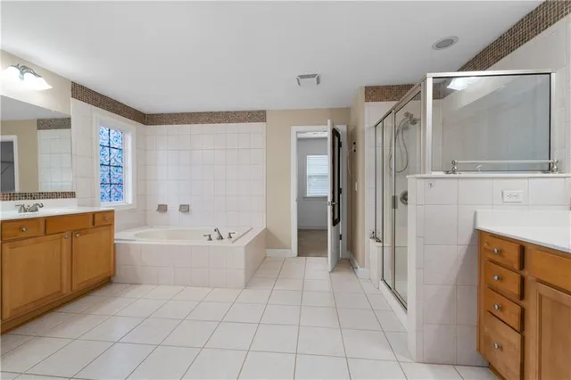 a spacious bathroom with a tub sink and mirror