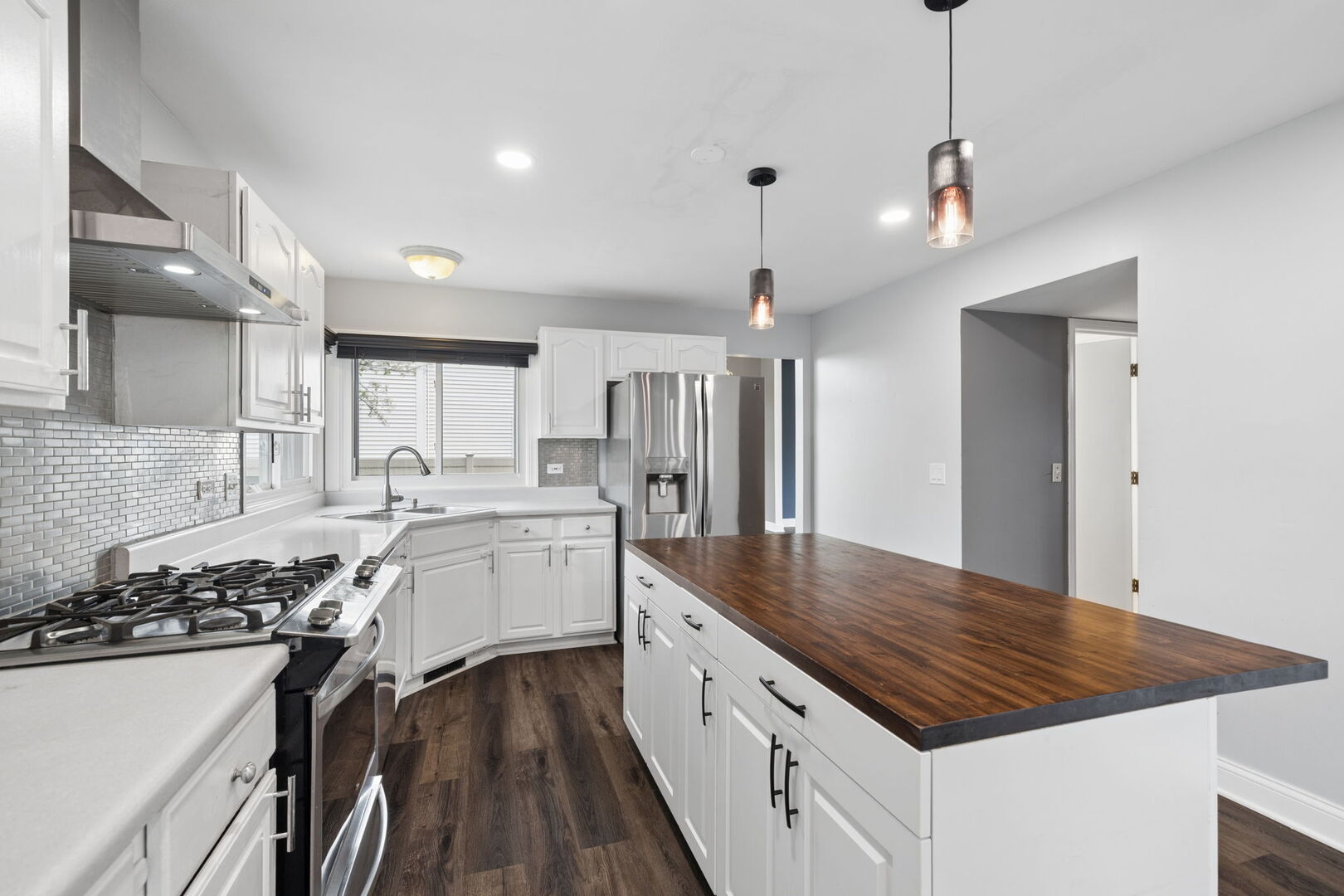740 Countryside Drive Bolingbrook, IL 60490 - Photo 8 of 29 a kitchen with a sink stove and wooden floor